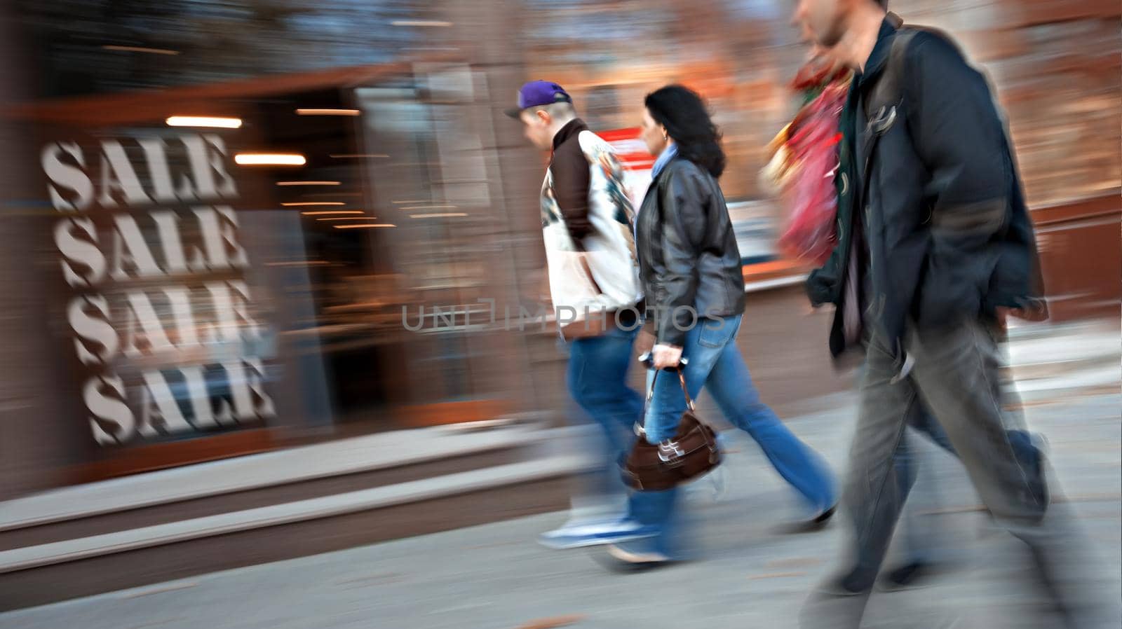 Group of people go to the store on sale. Intentional motion blur