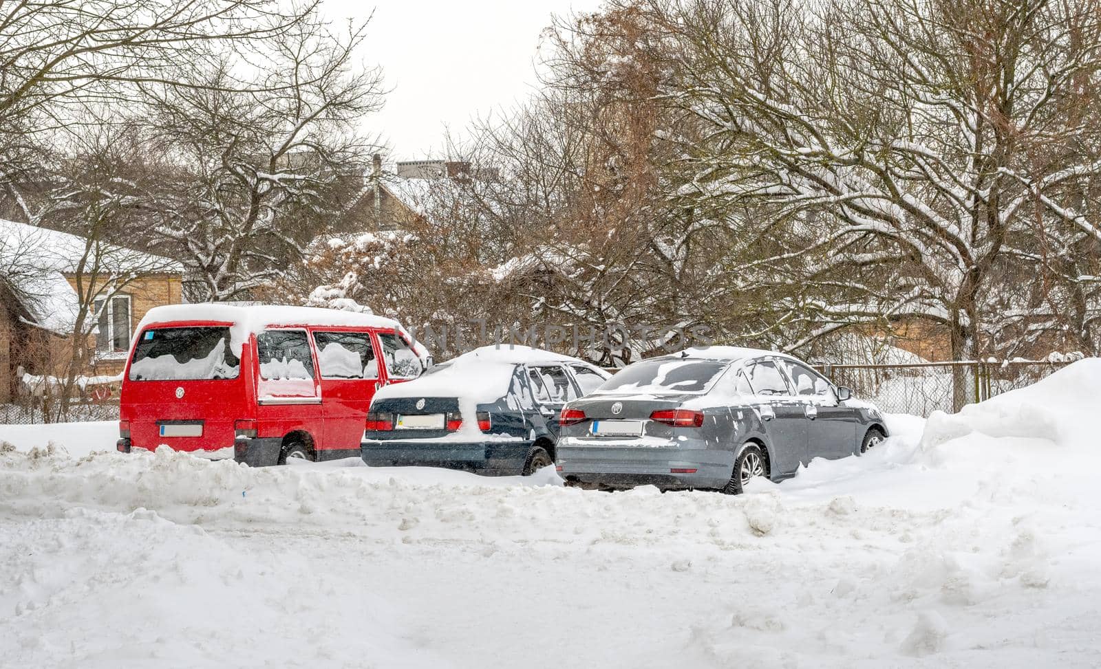 Lutsk, Ukraine - February 12,2020: Stuck car in snow and ice. City street after blizzard. Buried vehicle in snowdrift. Parking in winter after snowfall. Uncleaned road. Record-breaking amounts of snow