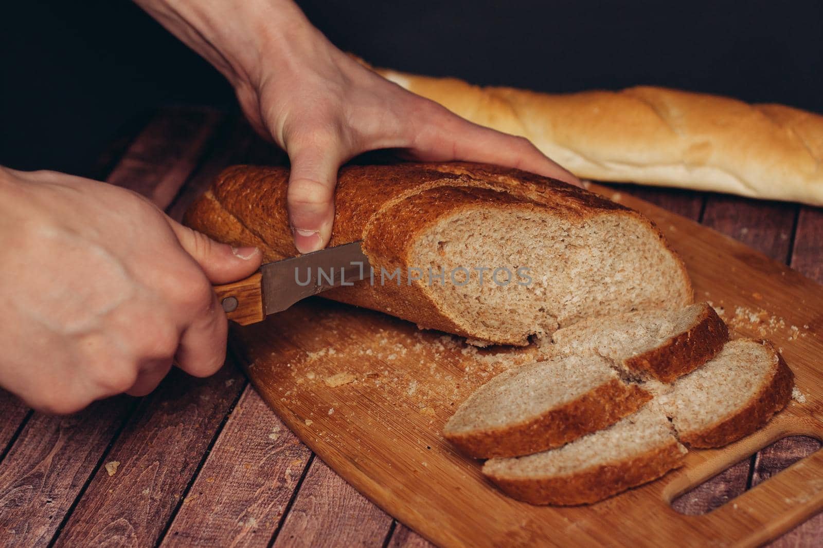 cutting a fresh loaf on a cutting board crispy bread kitchen meal. High quality photo