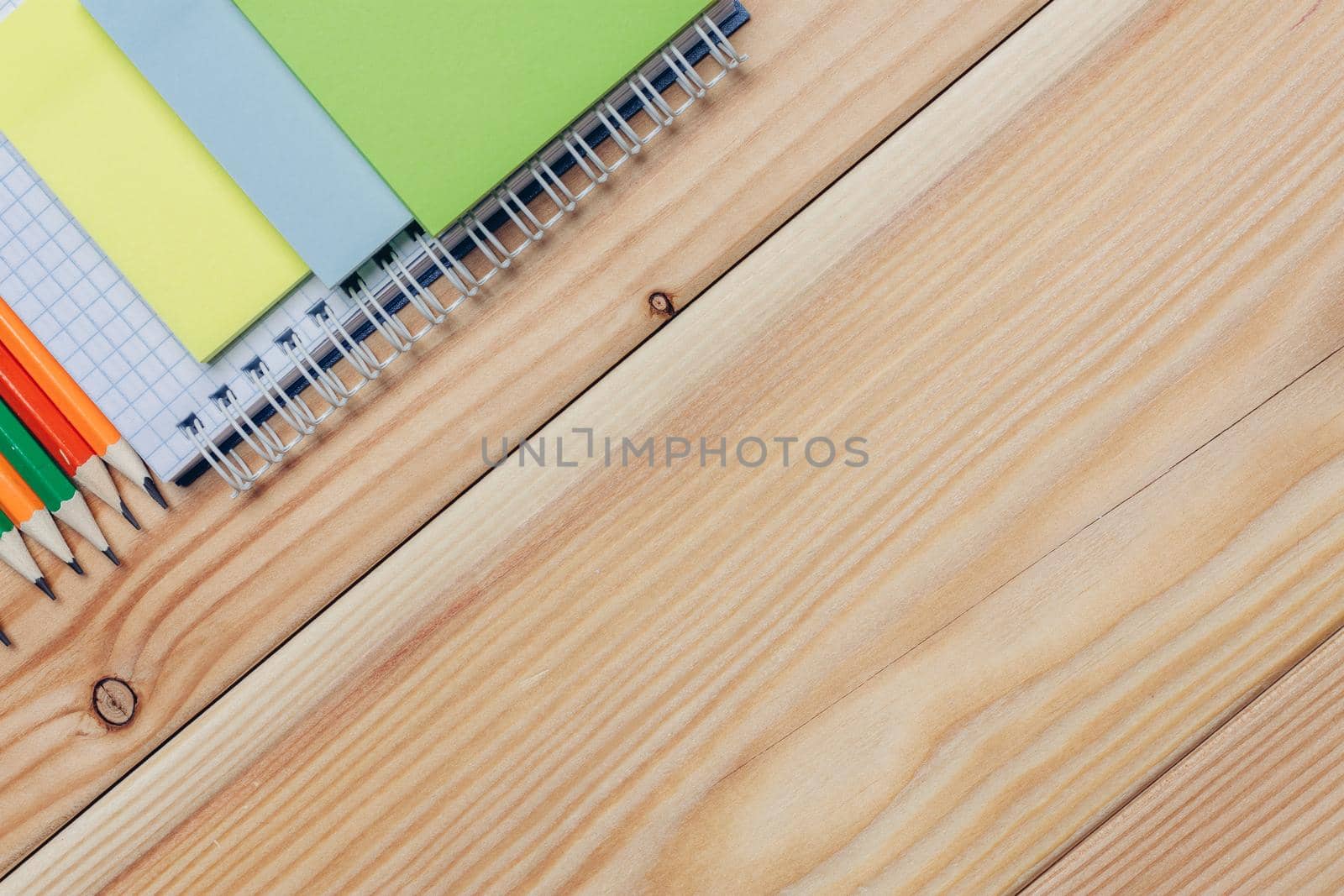 colorful notepads and pencils stationery wooden background close-up. High quality photo