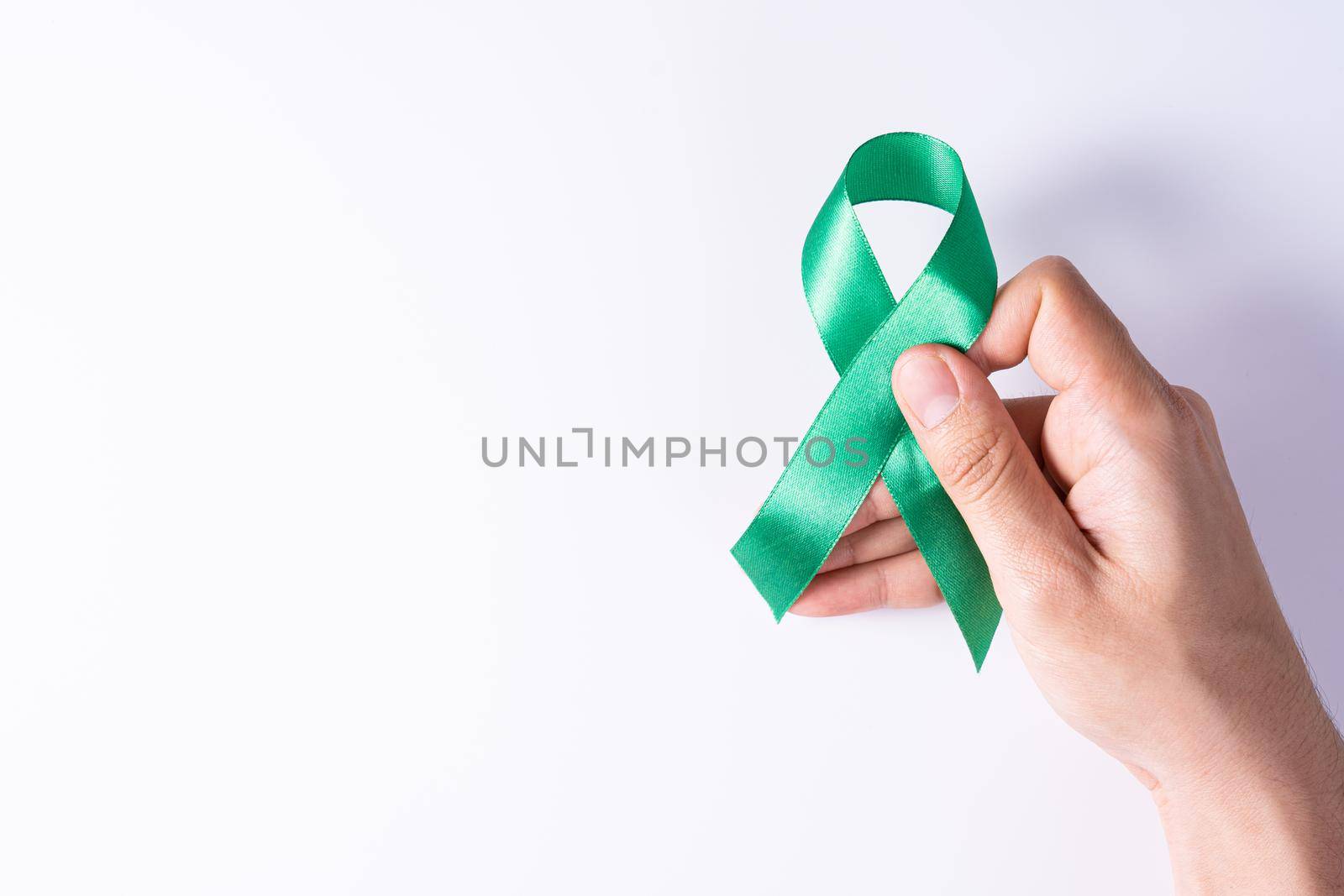 World kidney day, hands holding green ribbon awareness of kidney disease isolated white background.