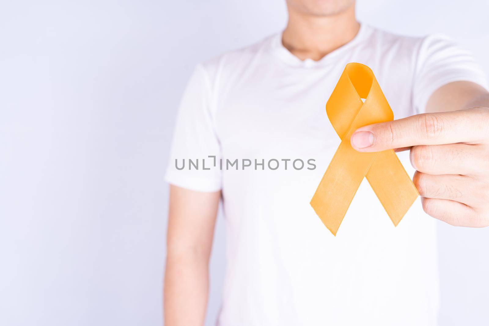 World kidney day, hands holding orange ribbon awareness of kidney disease on chest isolated white background.
