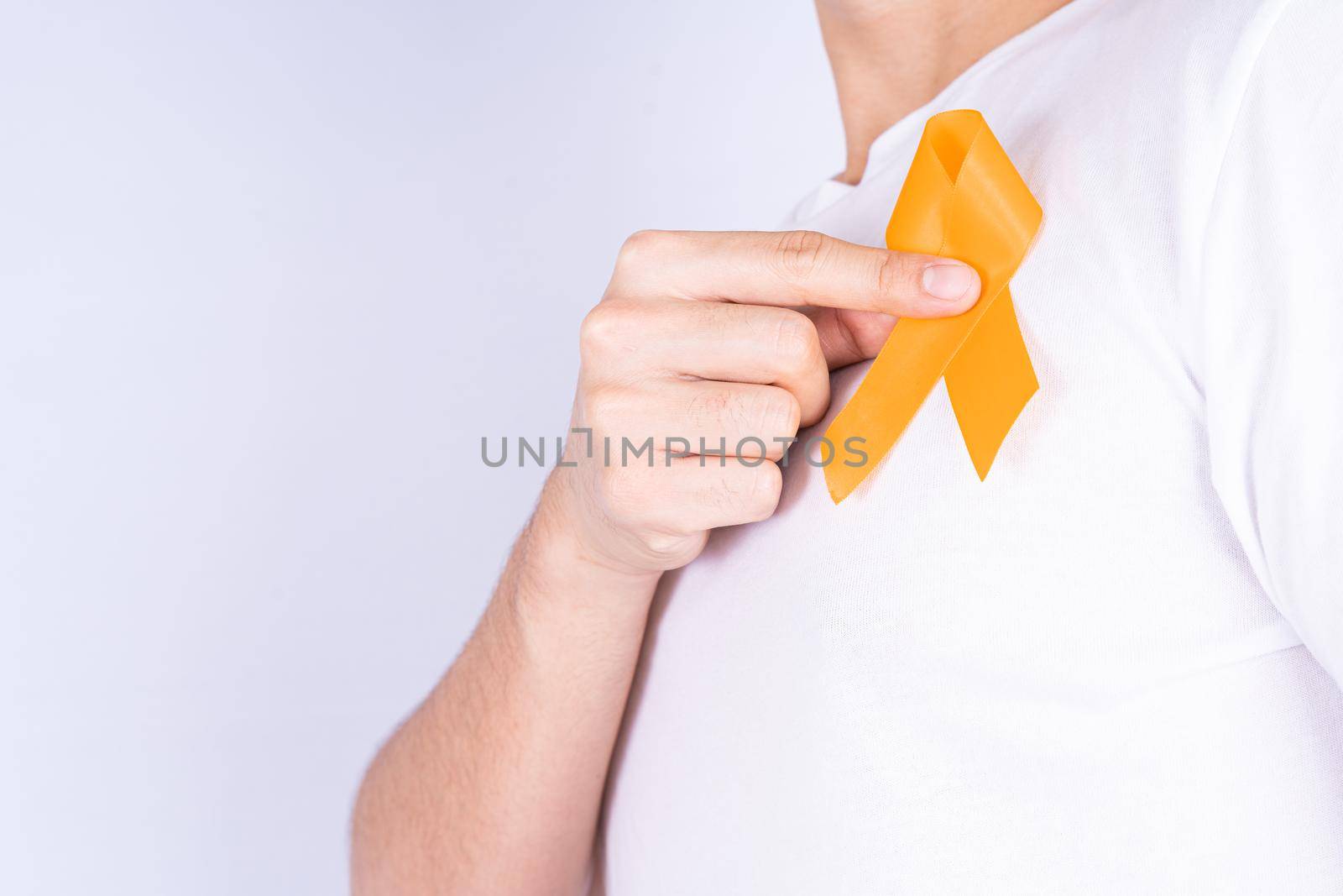 World kidney day, hands holding orange ribbon awareness of kidney disease on chest isolated white background. by mikesaran