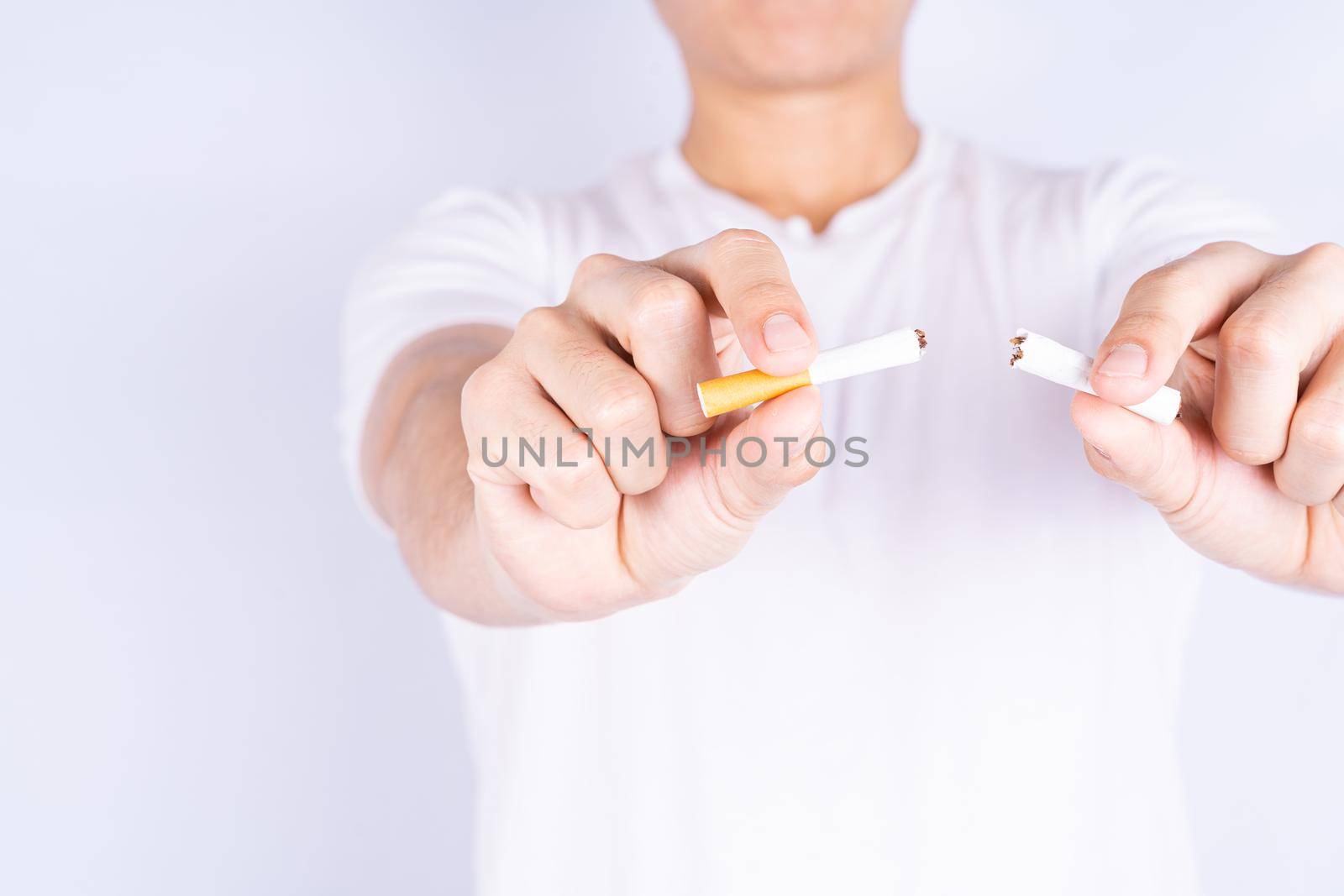 Male hand breaking or crushing cigarette. World no Tobacco and stop smoking day. by mikesaran