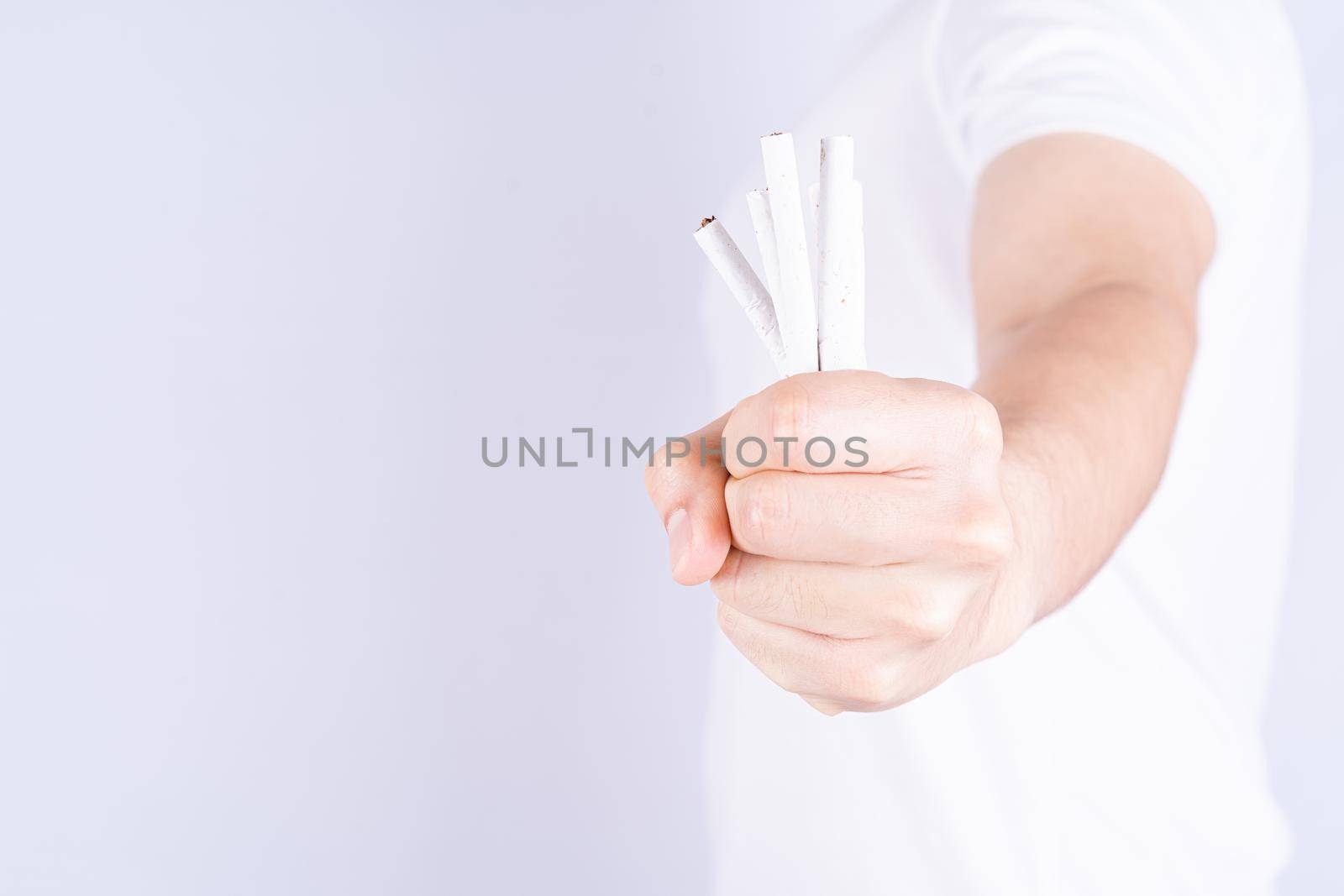 Male hand crushing cigarette. World no Tobacco and stop smoking day. by mikesaran