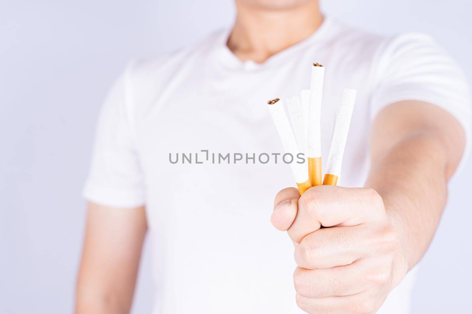 Male hand crushing cigarette. World no Tobacco and stop smoking day. by mikesaran