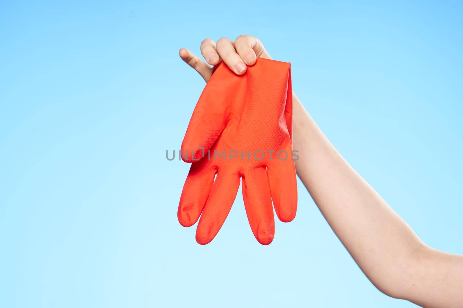 rubber glove in hand cleaning service blue background. High quality photo