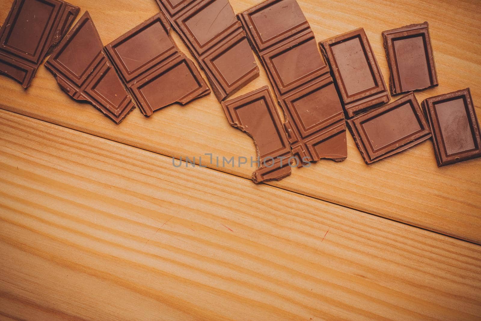 broken brown chocolate bar and background image texture top view. High quality photo