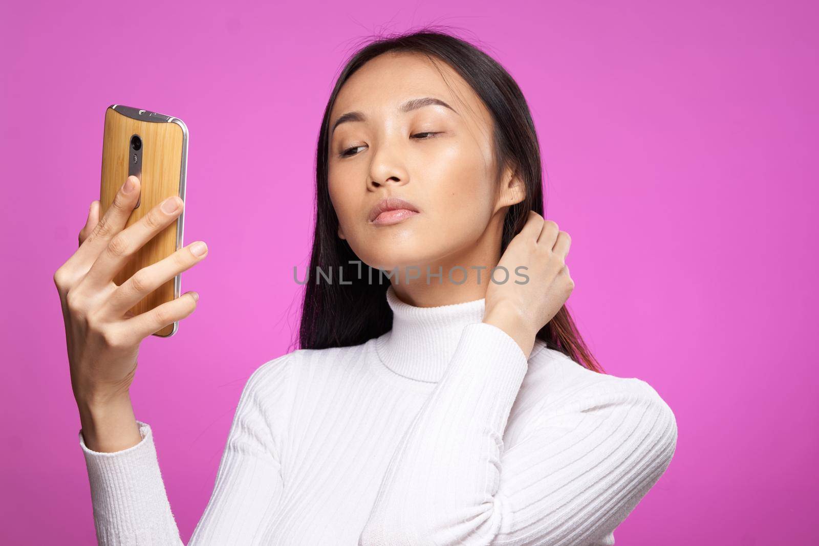 asian woman holding phone he communication technology internet pink background. High quality photo
