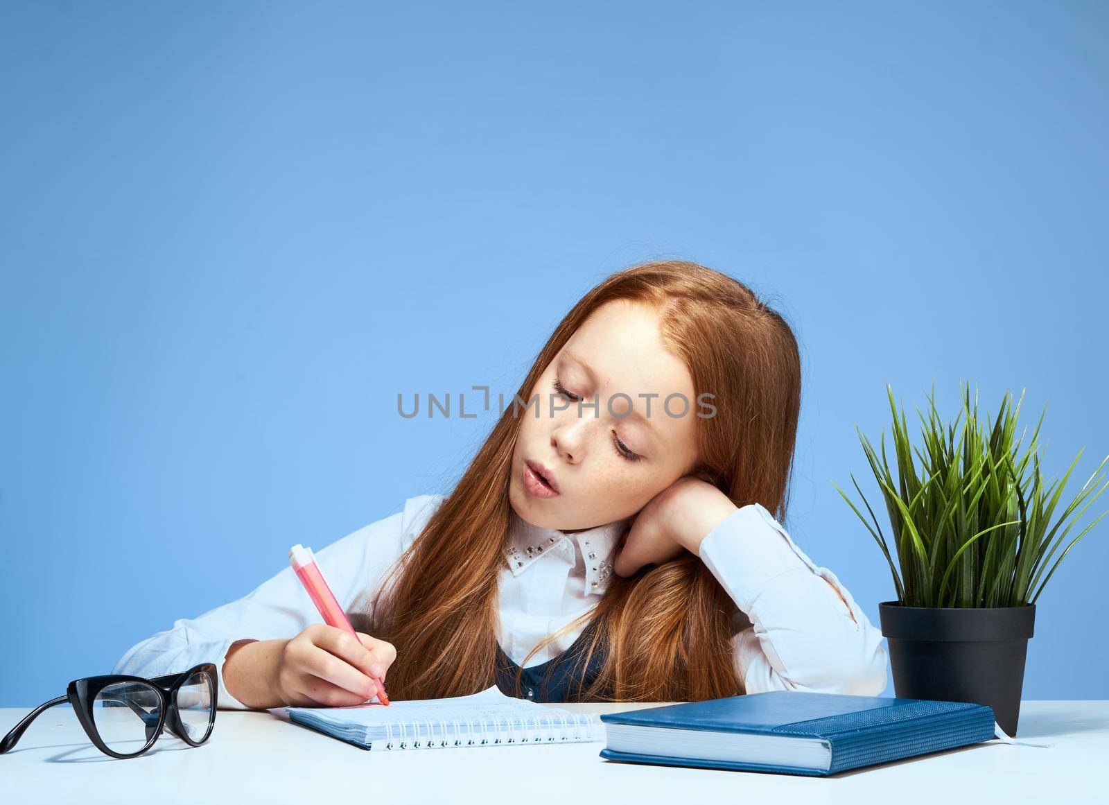 red-haired girl at a study desk doing lessons education school. High quality photo