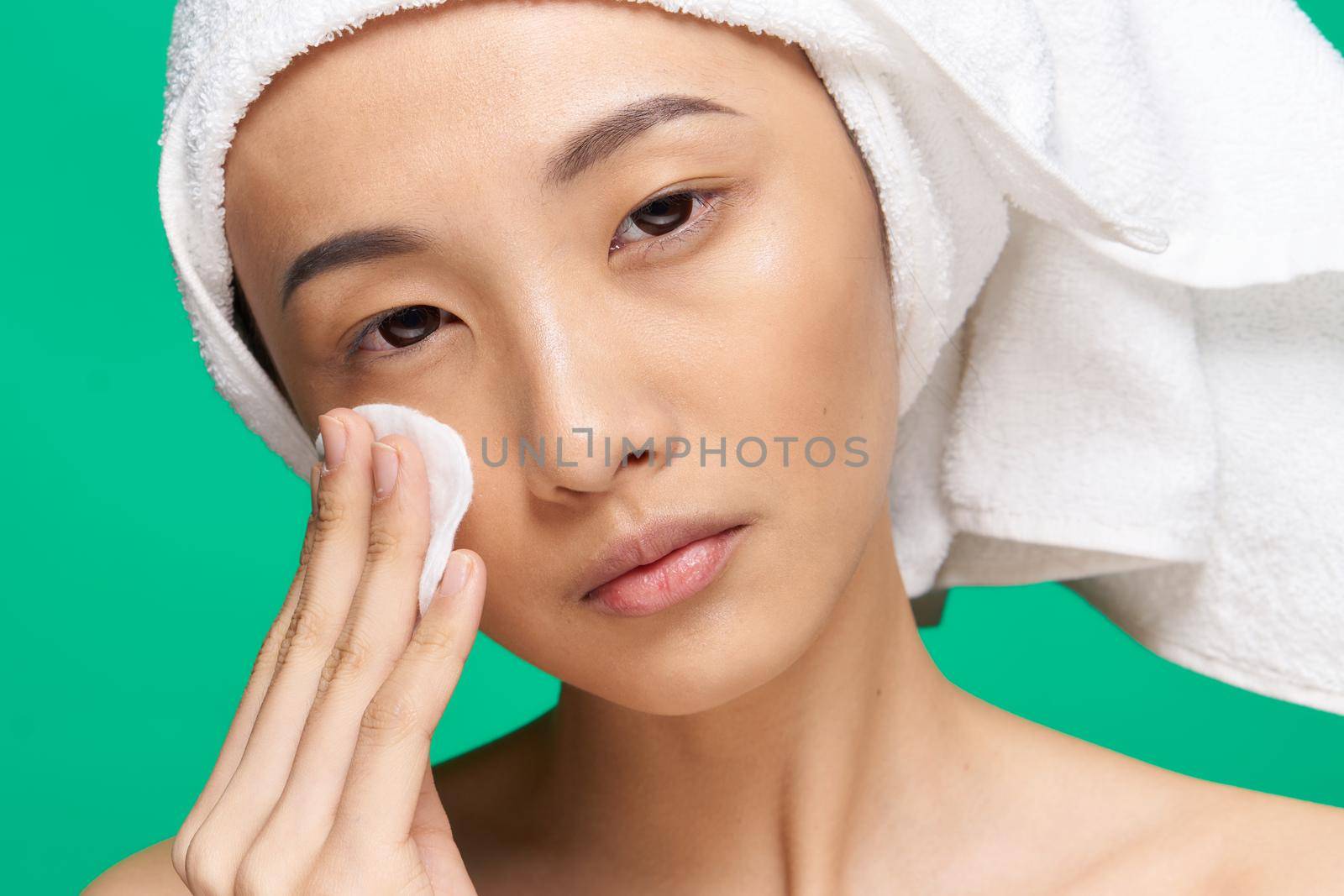 woman asian appearance clean skin close-up spa treatment green background. High quality photo