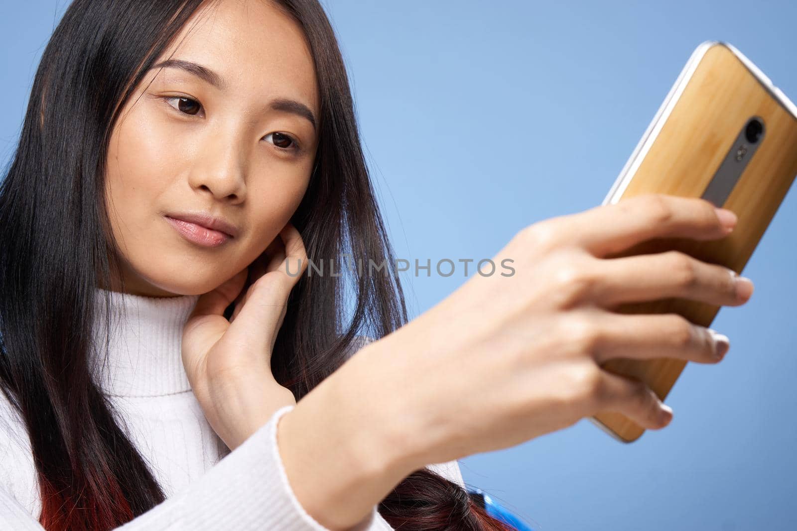 pretty brunette with a phone in her hands the charm of internet communication technology close-up by SHOTPRIME