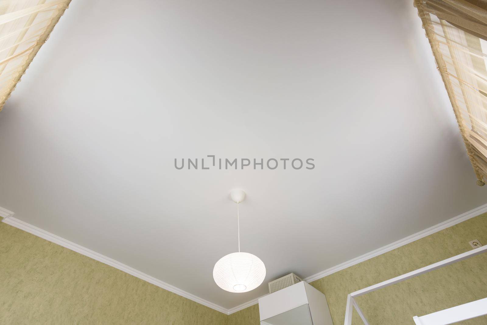 Stretch white matte ceiling close-up in the interior of a bedroom by Madhourse
