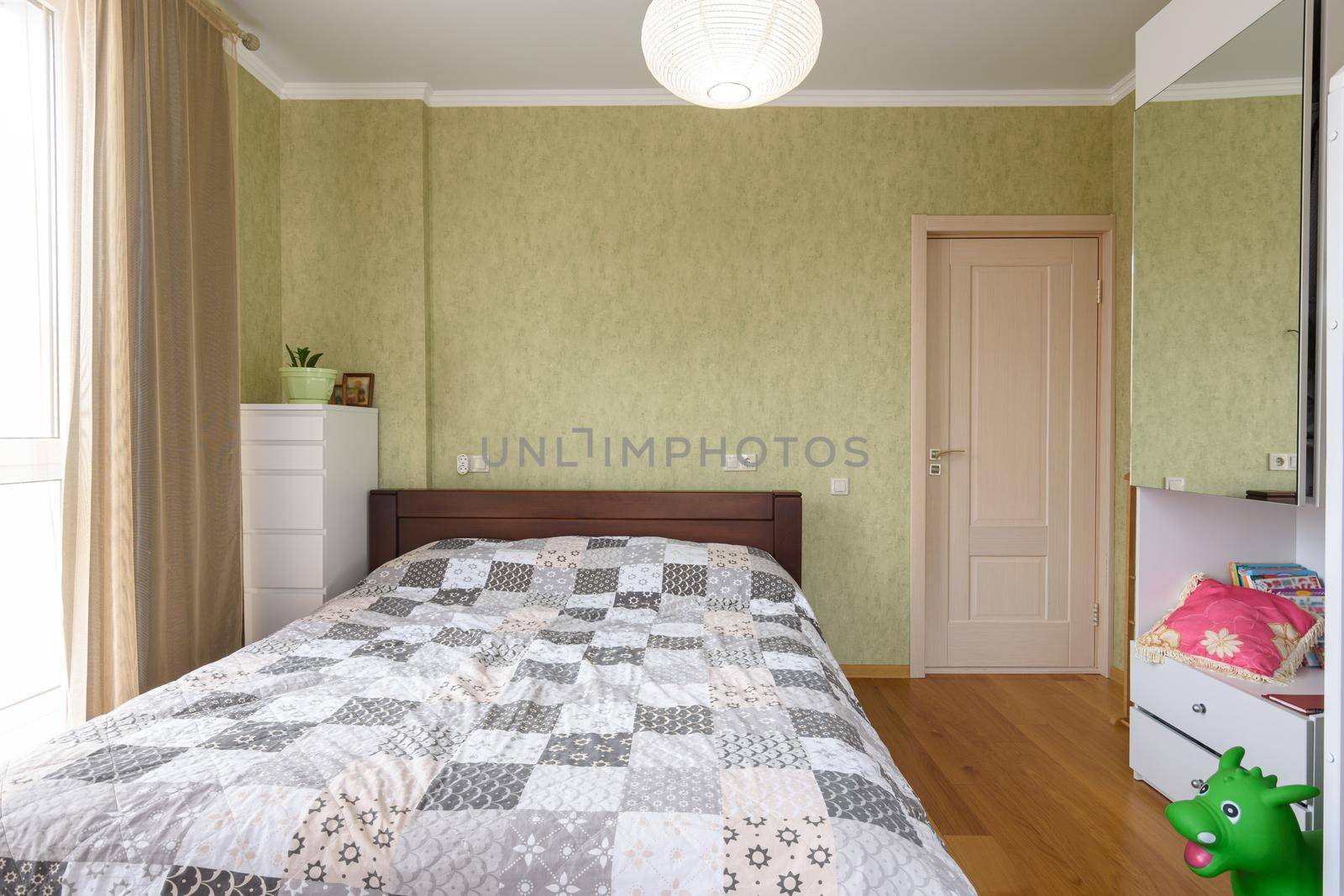 Bedroom interior with a large double bed and a wardrobe with a mirrored door