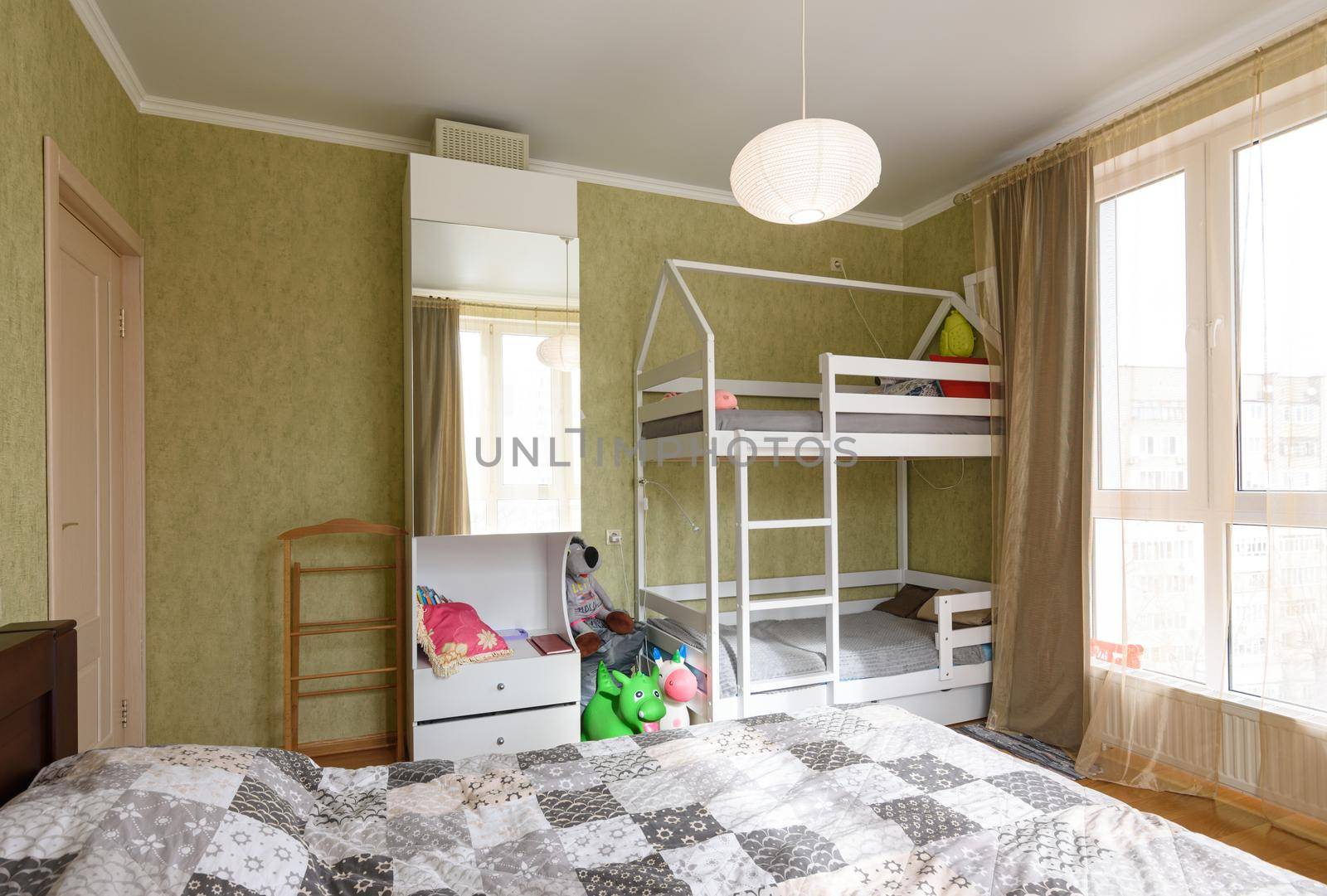 Interior of an adult bedroom, in the room there is a children's bunk bed