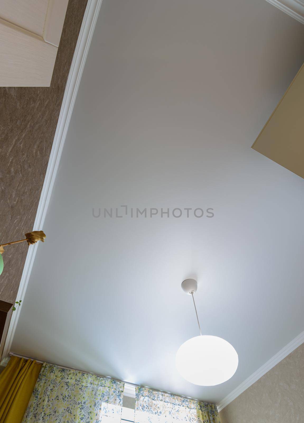 Stretch white matte ceiling with a chandelier in the interior of a rectangular room by Madhourse