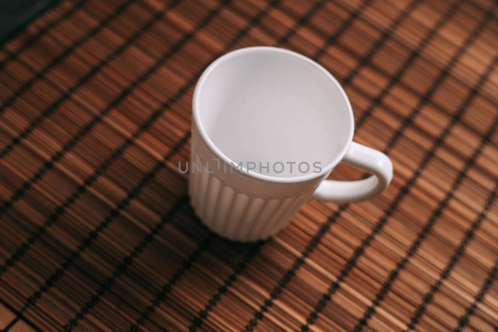 white mug on a wooden stand stands on the table top view. High quality photo