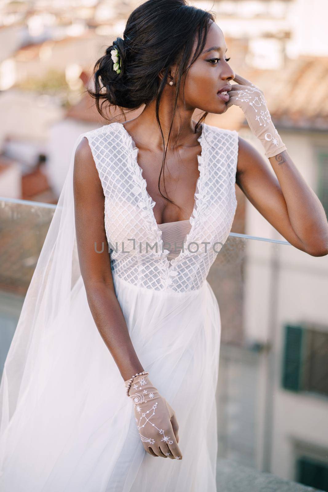Beautiful African American bride in a white wedding dress, touches her face in vintage gloves. Fine-Art Wedding in Florence, Italy. by Nadtochiy
