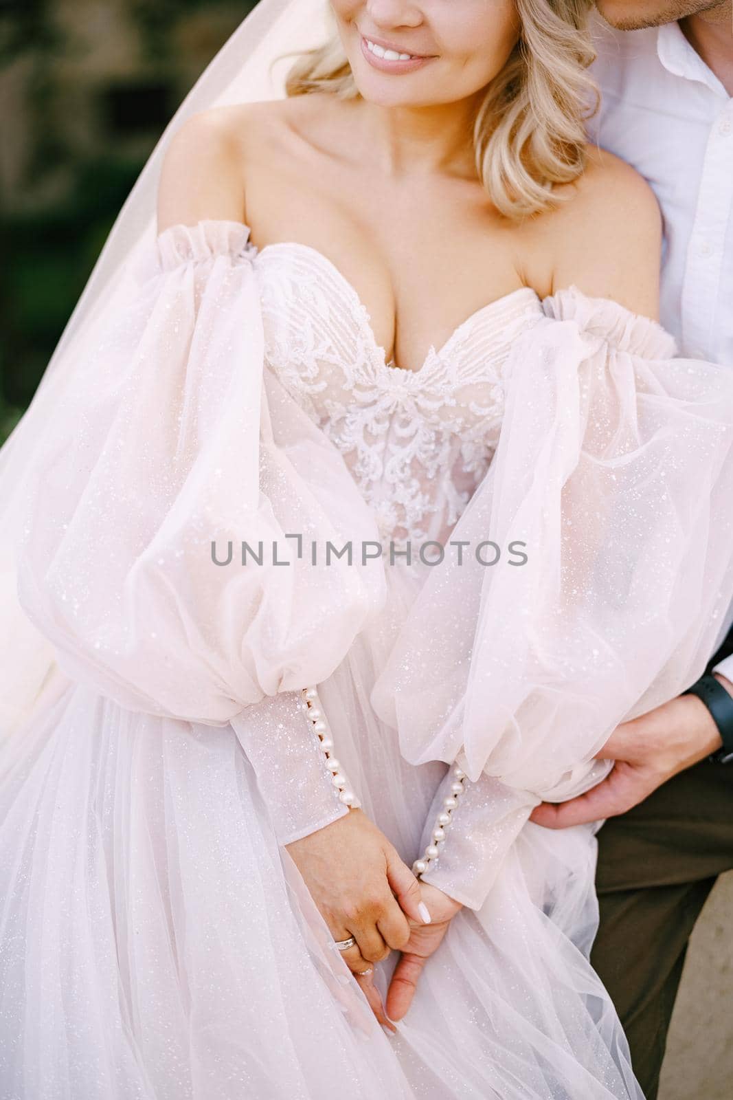 Close-up portrait of a wedding couple, the groom hugs the bride. Wedding at an old winery villa in Tuscany, Italy.