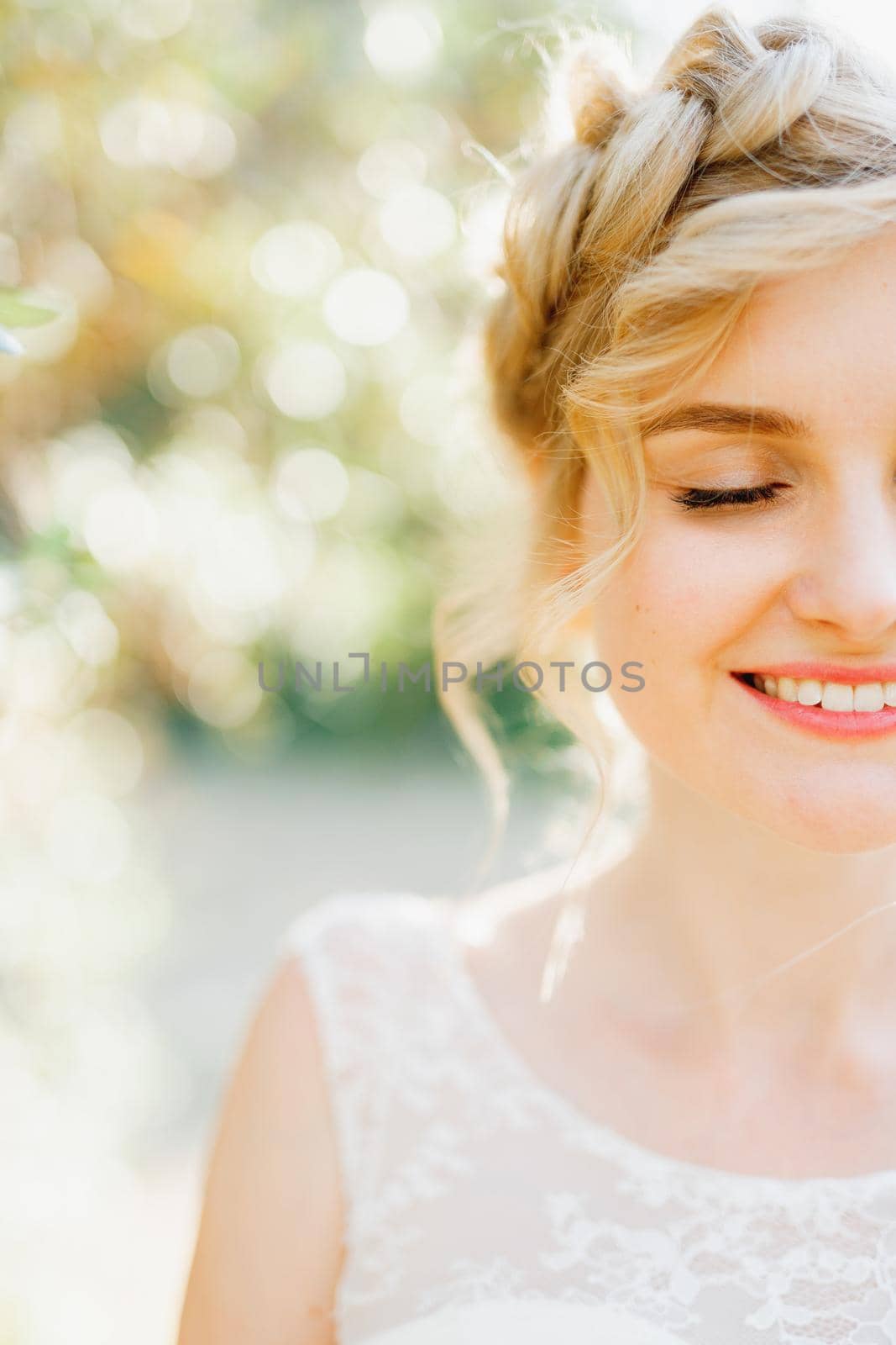 Blonde woman with beautiful hairstyle smiling happily with closed eyes on a sunny day, close-up . High quality photo
