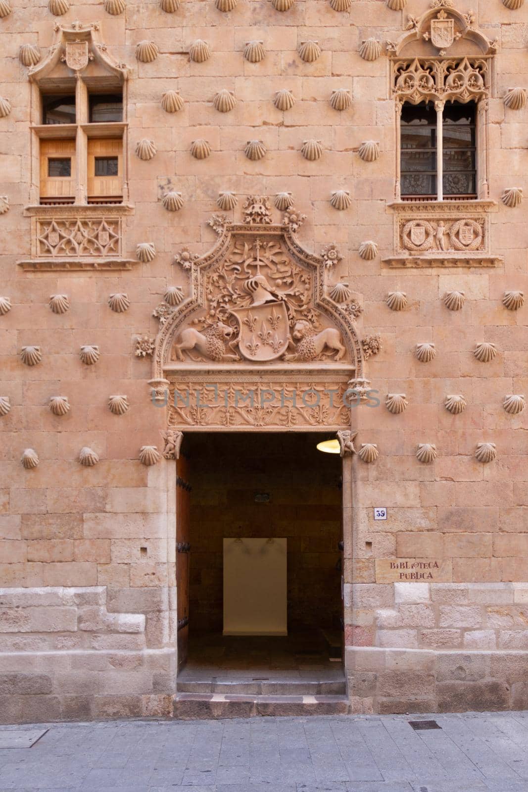 Detail of a door and two windows at Casa de las Conchas in Salamanca