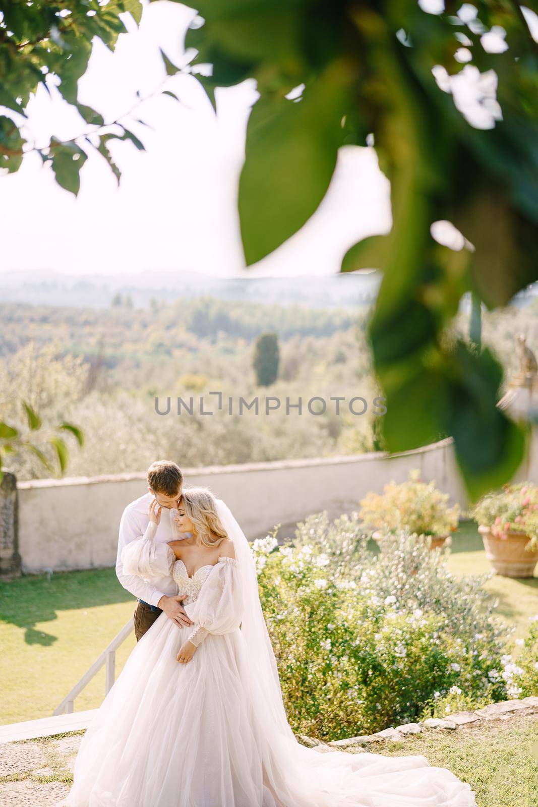 Wedding couple in the garden at sunset. Wedding in Florence, Italy, in an old villa-winery.