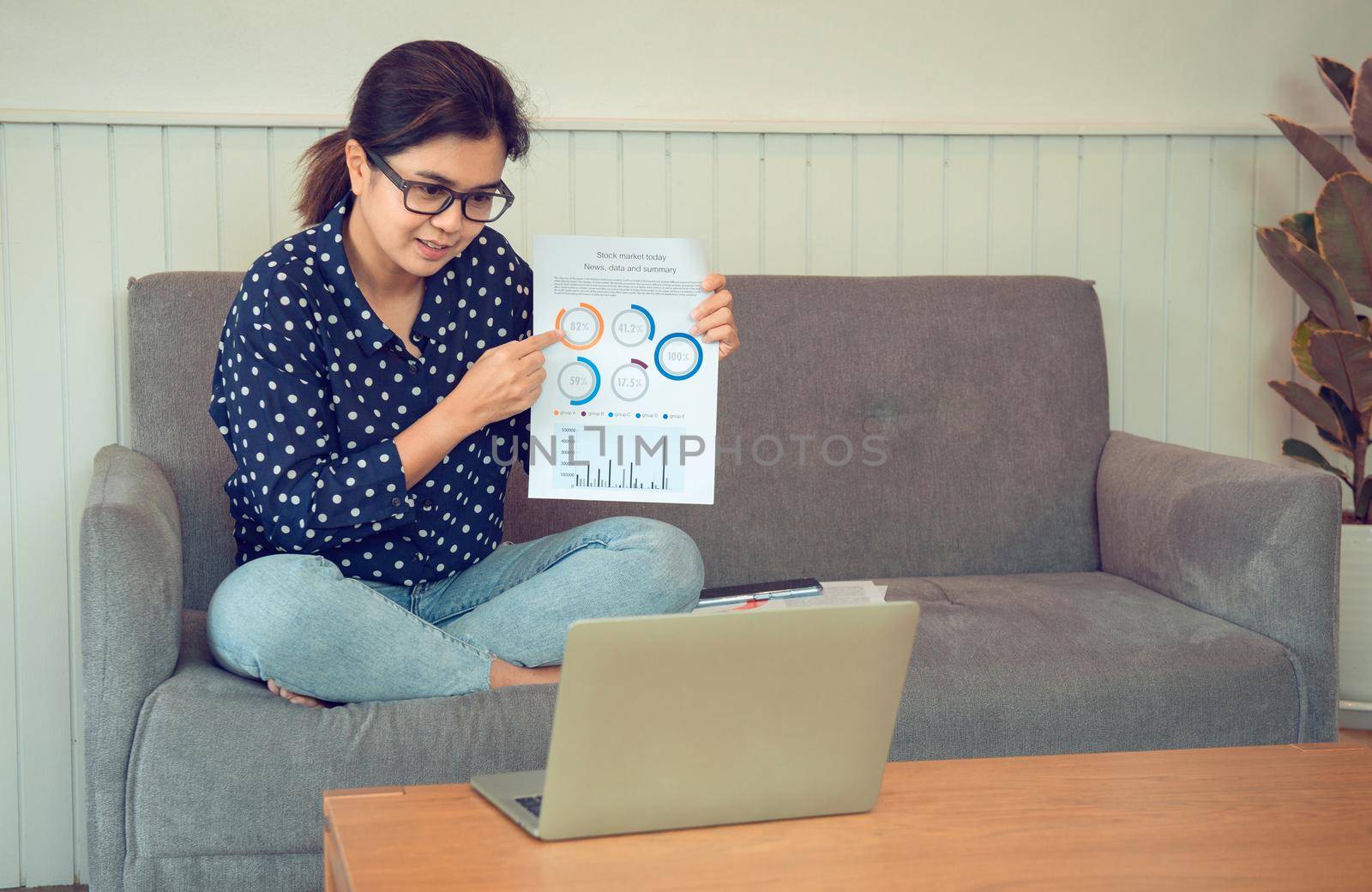 Business woman holding paperwork and video calling via laptop talk to assistant in home.