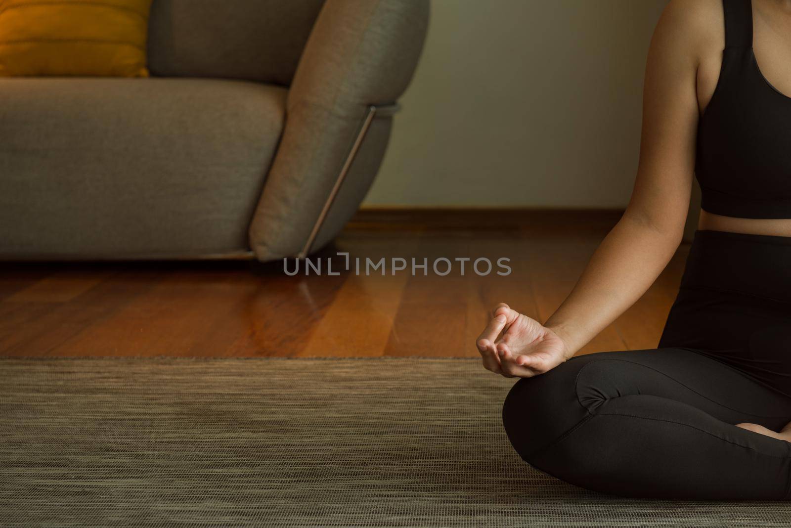 Young woman practicing yoga, attractive sporty girl in black sportswear, independent concepts, relaxing women 's happiness. working out at home or in yoga studio close up.