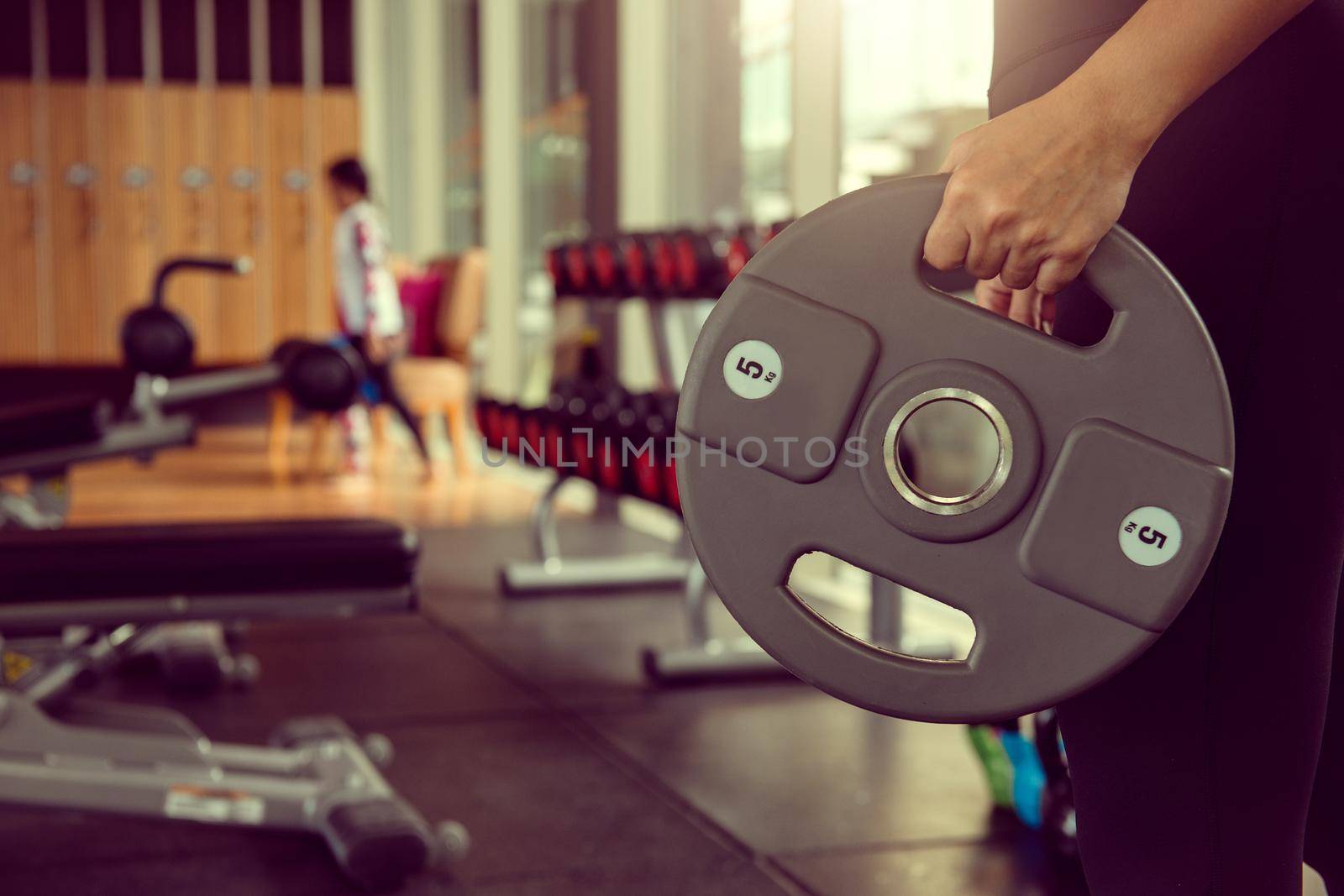 Young woman lifting weights on training class at gym. Concept fitness ,workout, gym exercise ,lifestyle and healthy. by thanumporn