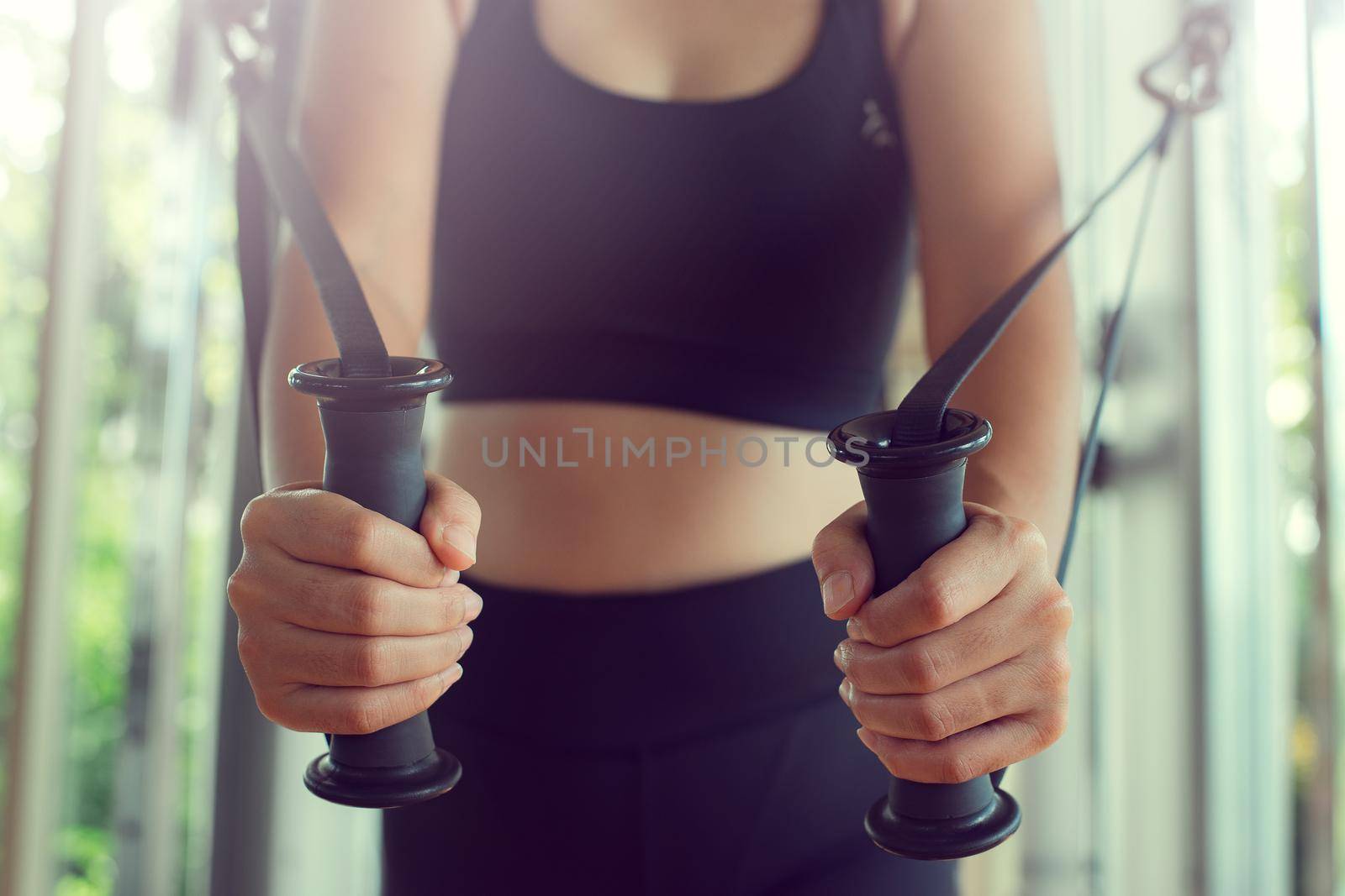 Young woman with perfect body training triceps with cable exercise machine in the gym. Concept fitness ,workout, gym exercise ,lifestyle and healthy. by thanumporn