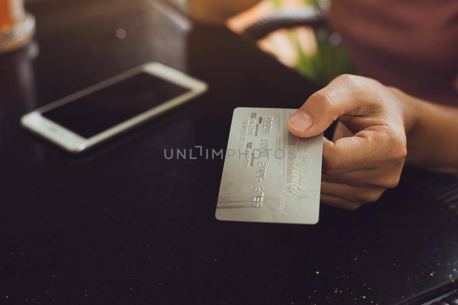 Woman hands holding smart phone with credit card for Online shopping.