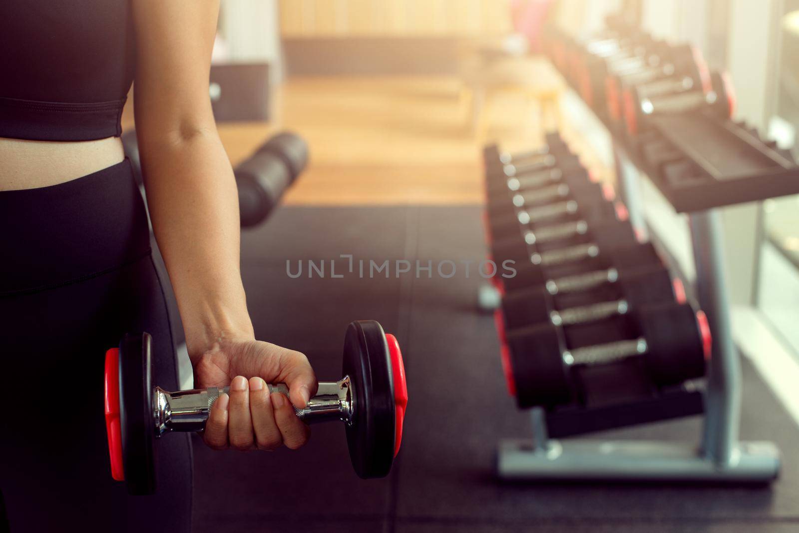 Young woman lifting weights on training class at gym. Concept fitness ,workout, gym exercise ,lifestyle and healthy. by thanumporn