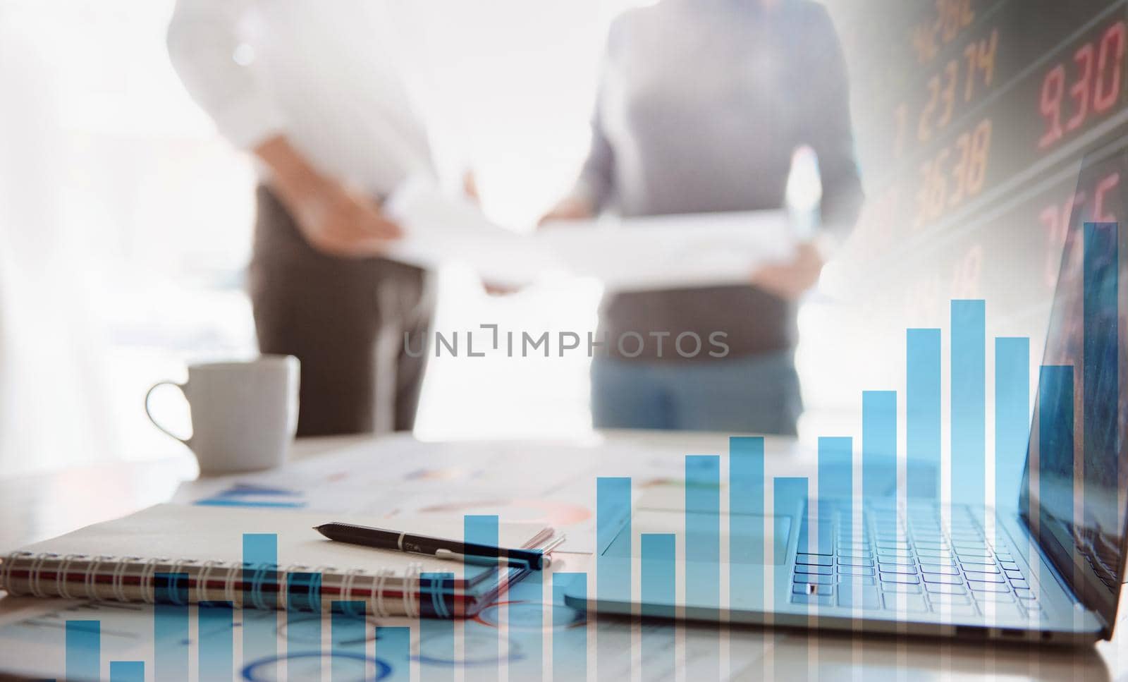 Two business people working together on corporate strategy. Try to analyze statistics. Financial forecast graph hologram. Double exposure. by thanumporn