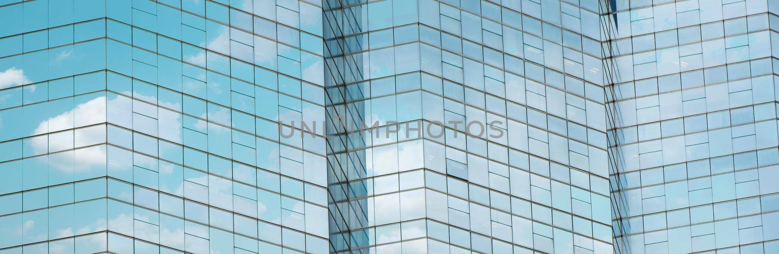 Cloud reflected in windows of modern office building.