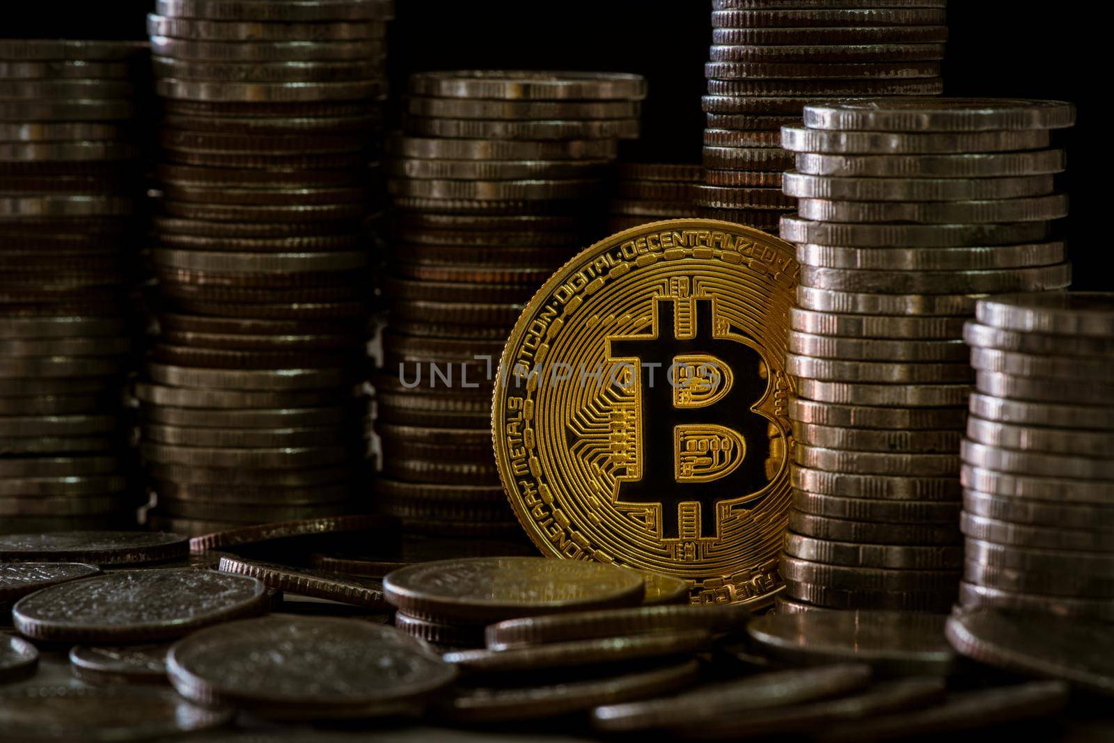 Bitcoin medal with group of thailand baht stacks background. by thanumporn