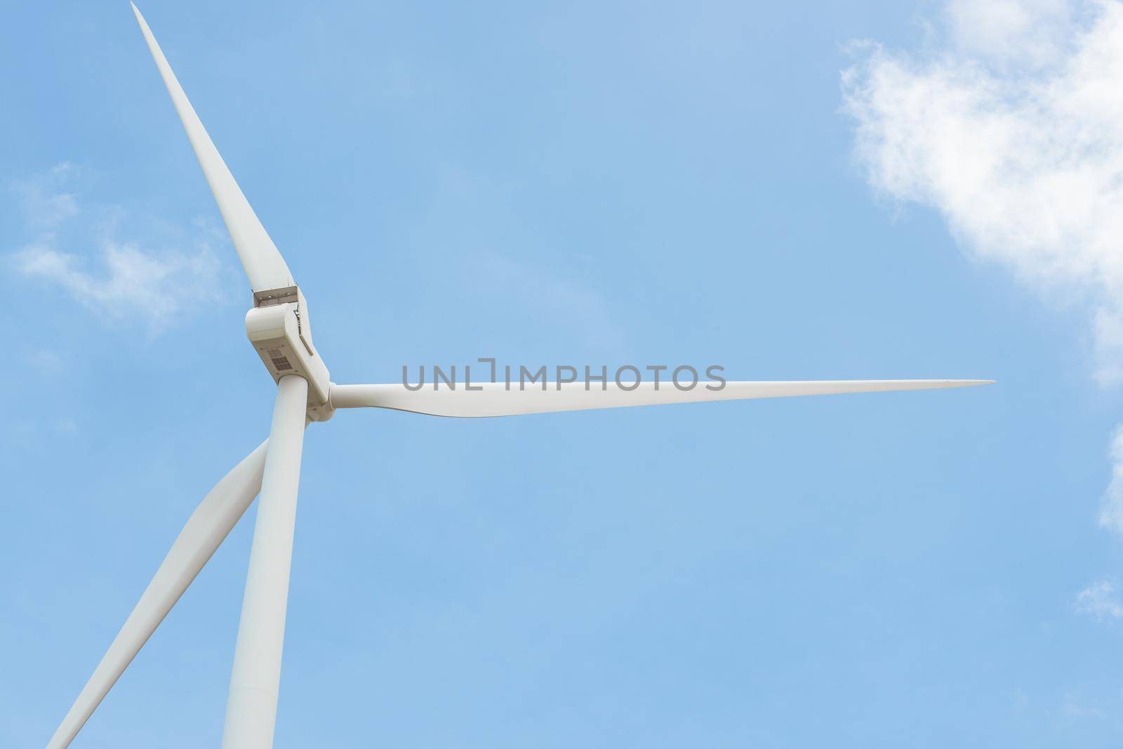Close-up wind turbine in rotation to generate electricity energy on outdoor with  blue sky background, Conservation and sustainable energy concept. by thanumporn