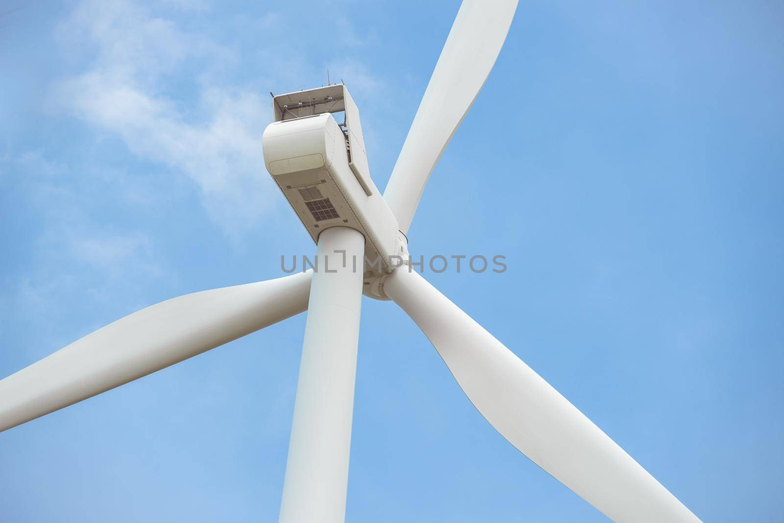 Close-up wind turbine in rotation to generate electricity energy on outdoor with  blue sky background, Conservation and sustainable energy concept.