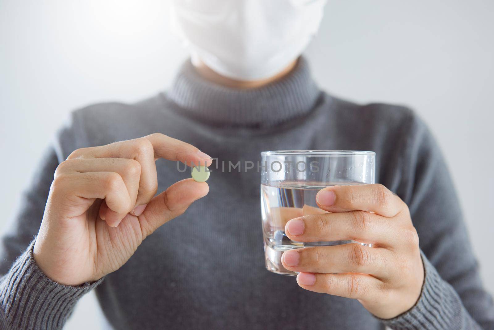 Close-up woman holding pills against the virus isolate on white background. Coronavirus or COVID-19 concept. Medical concept of Virus Pandemic Protection, Coronavirus COVID-19. by thanumporn
