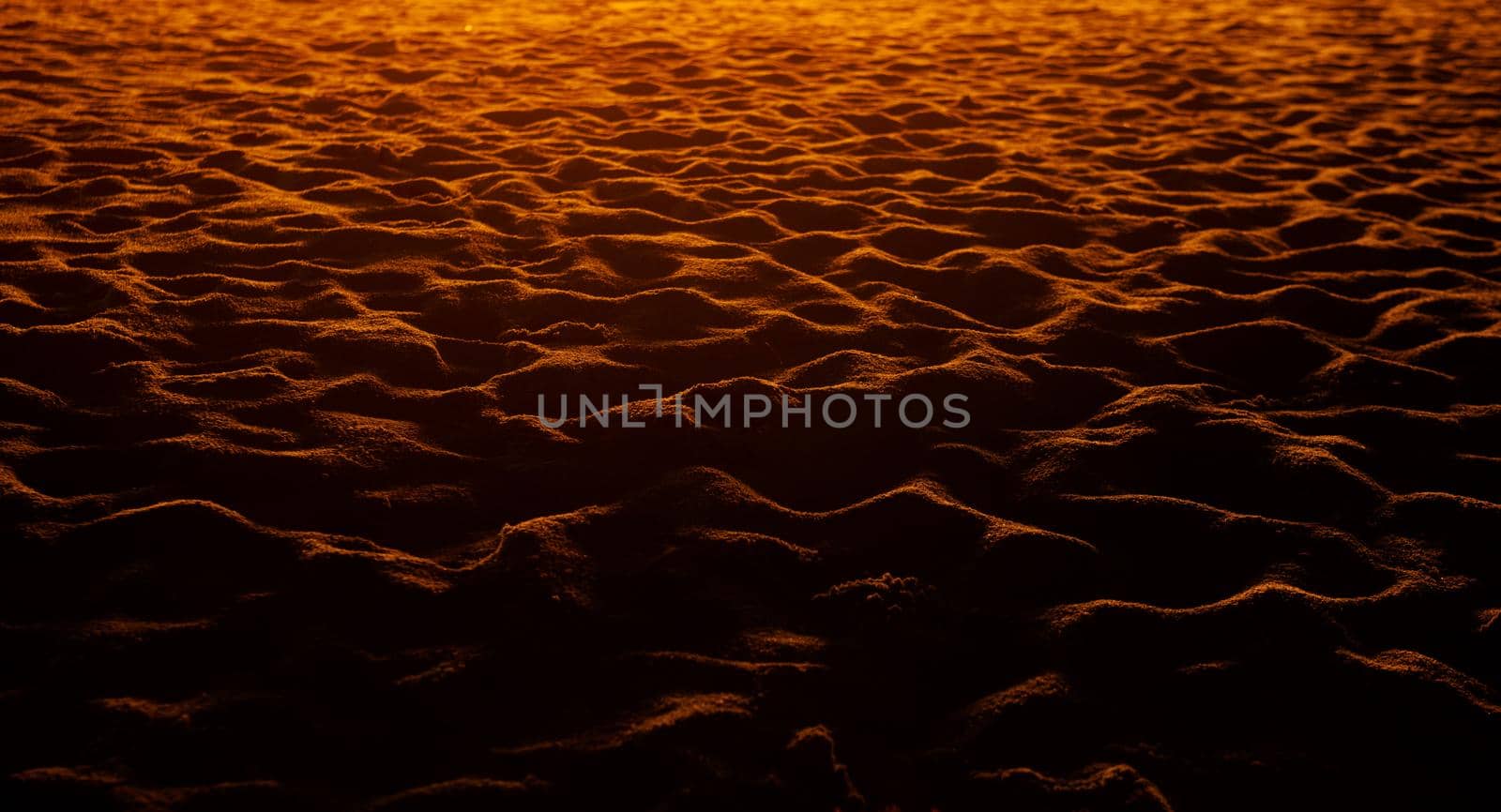 closeup of sand pattern of a beach in the sunset.