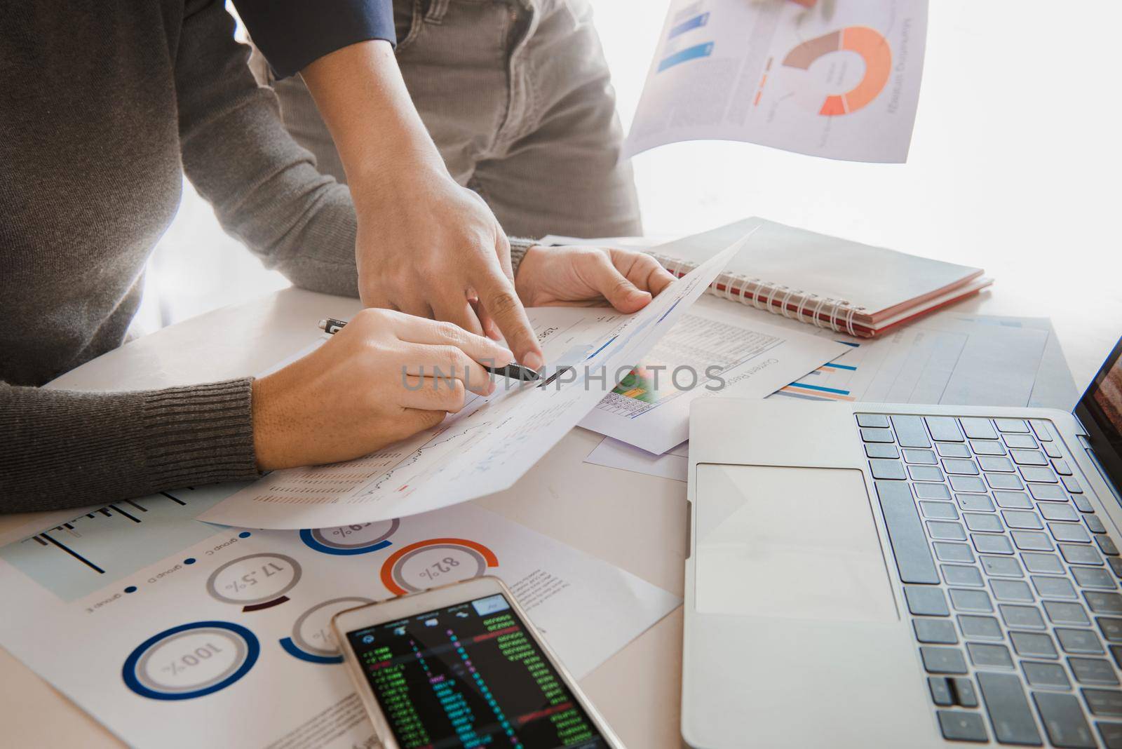 Business team analyzing sales data and economic growth graph chart on office table with laptop and smart phone, Brainstorming, Business strategy and planning.