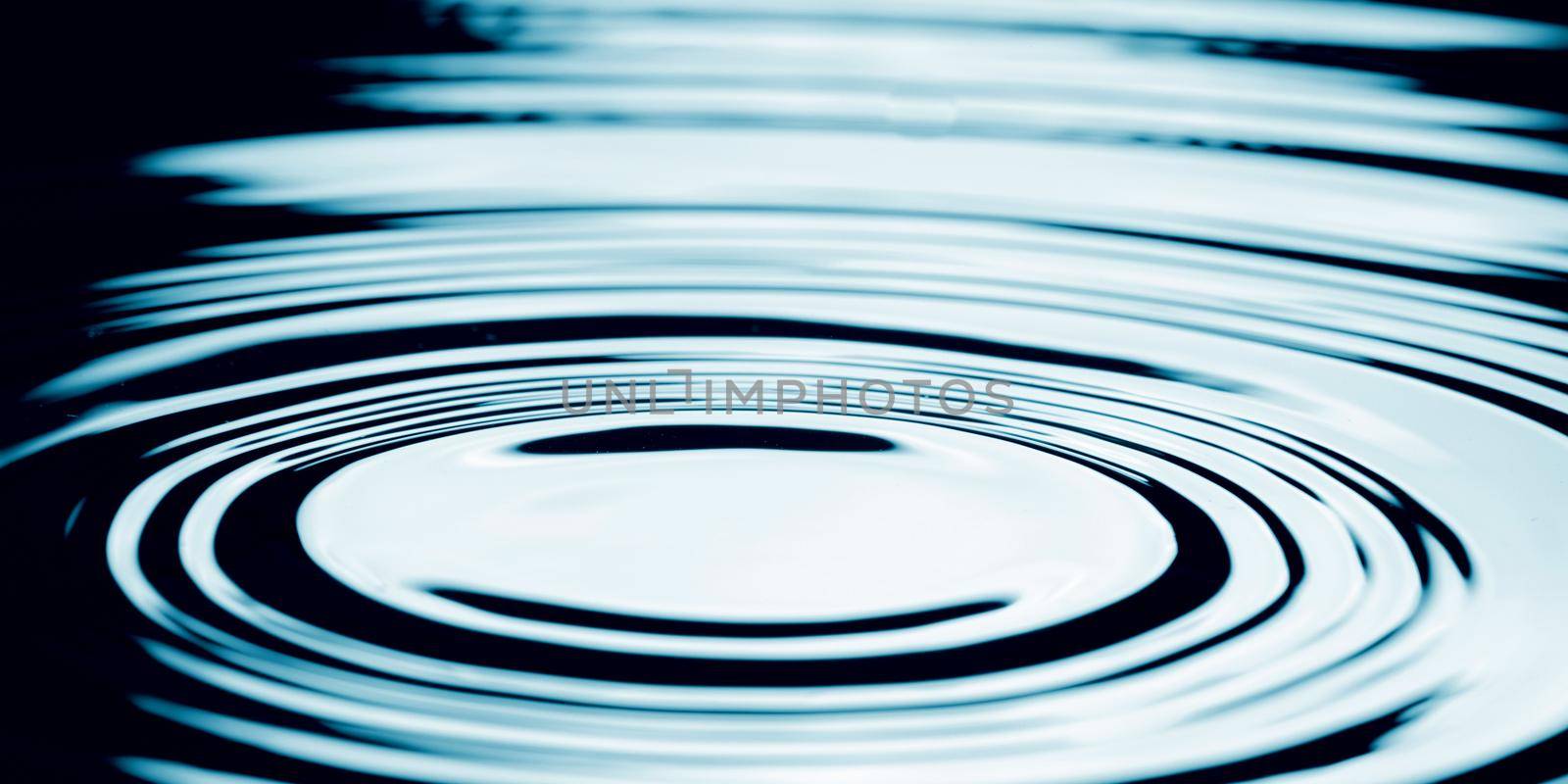 Water drop falling into water making a perfect concentric circles. by thanumporn