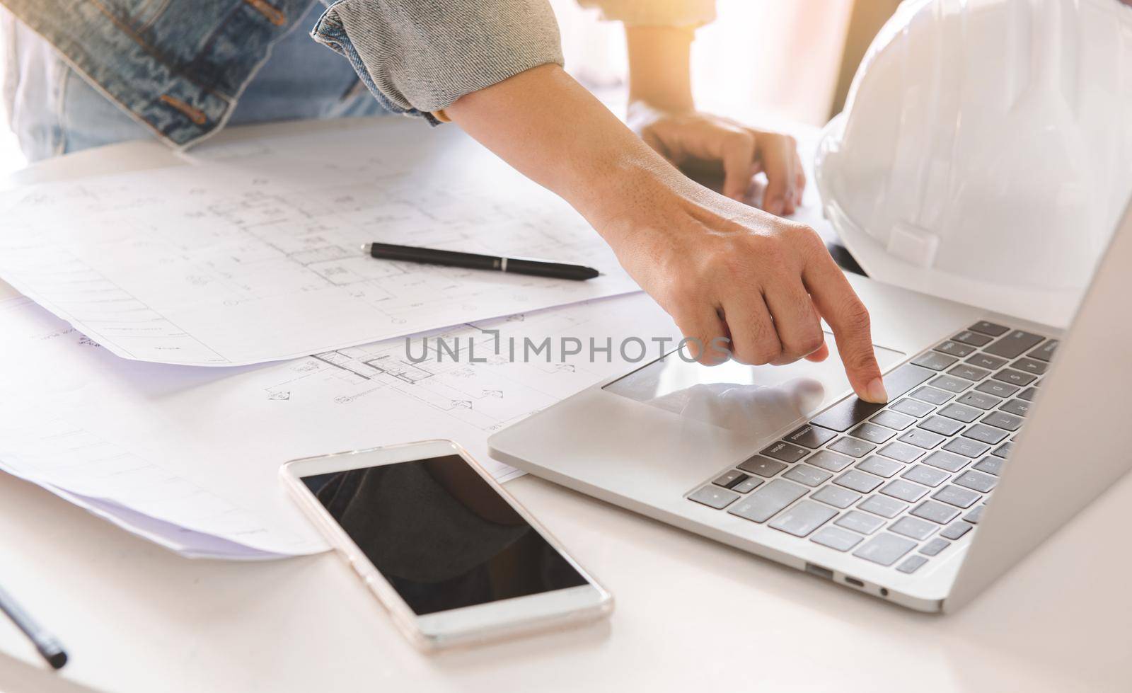 Top-View of engineers or architect using laptop to planning project schedule. Engineering and construction concept. by thanumporn