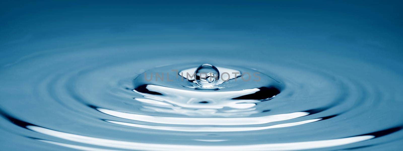 Water drop falling into water making a perfect concentric circles. by thanumporn