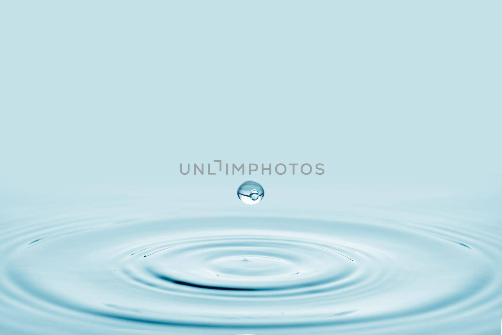 Close-up blue water drop falling down. by thanumporn