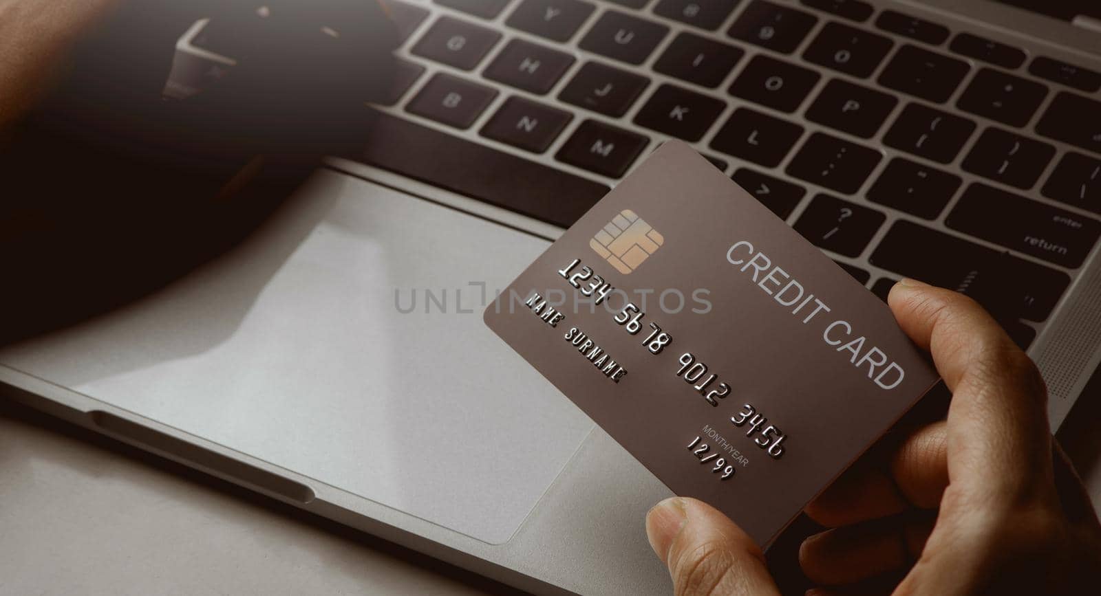 Clos up hands holding credit card and using laptop. Online shopping and paying concept.