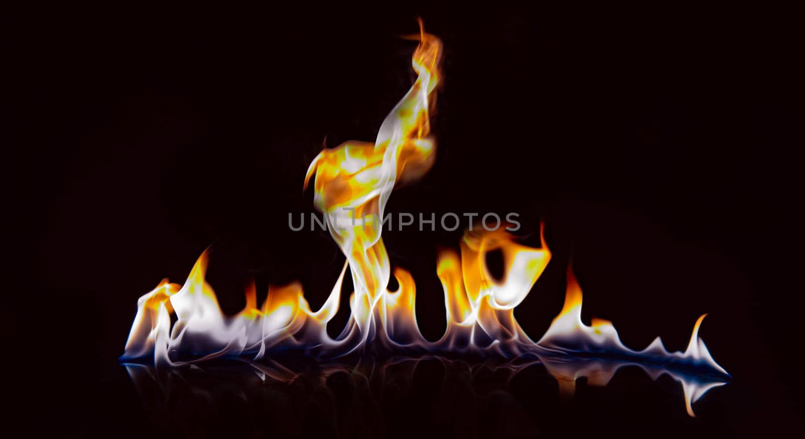 Beautiful flame with reflection on a black background. by thanumporn