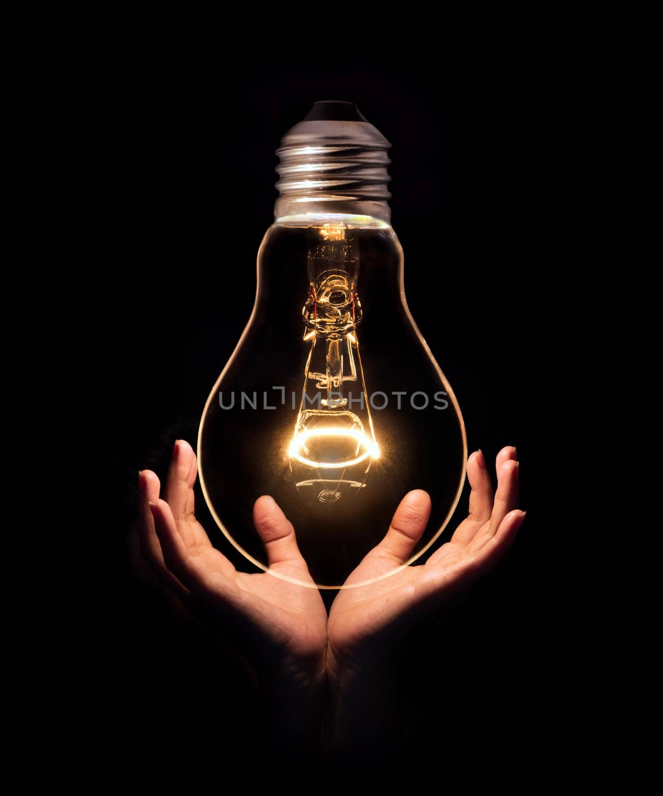 Lightbulb on hand isolate on black background.Energy or idea concept