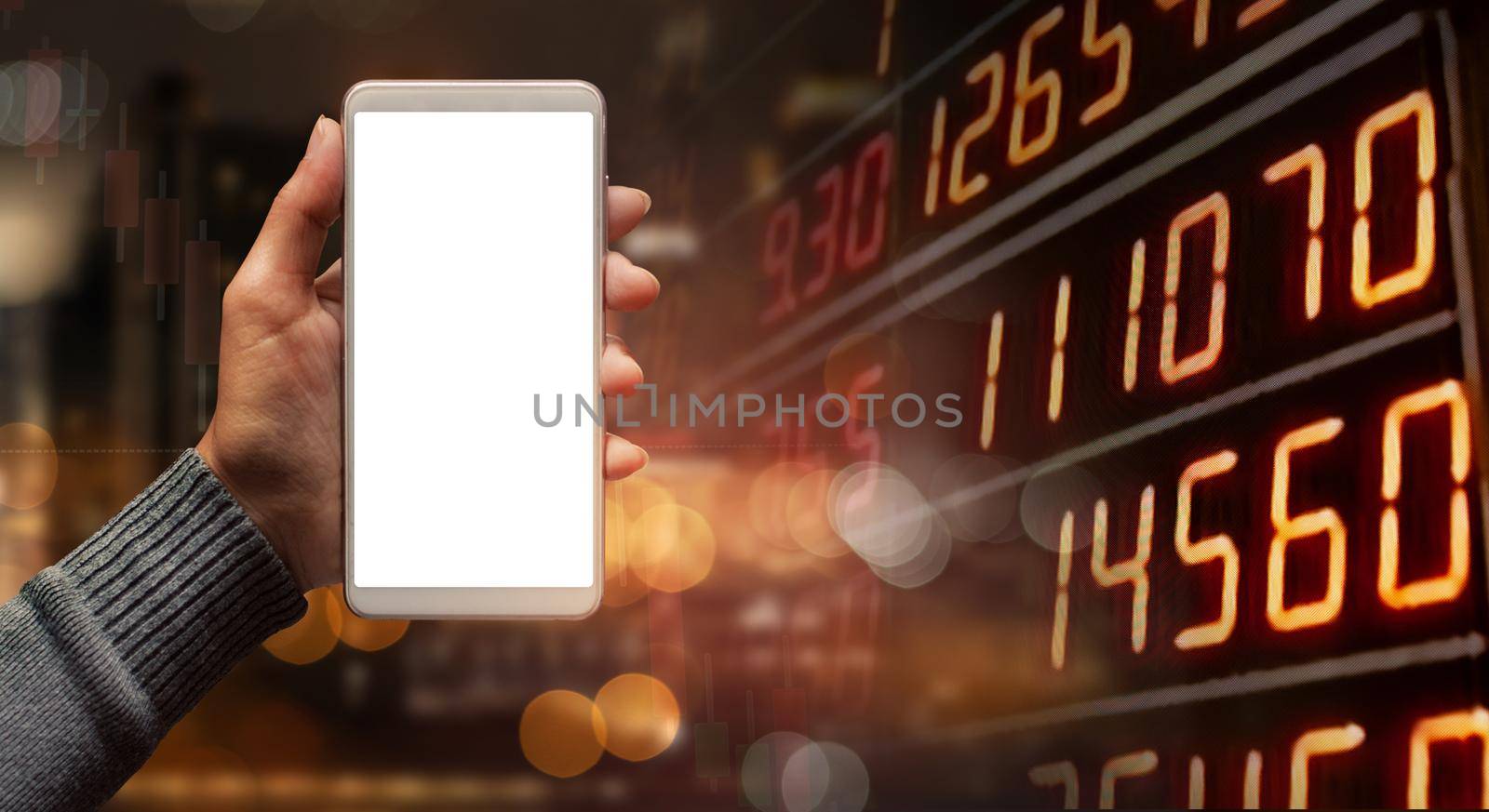 Hand holding phone on graph stock market background businessman blank white screen card. Financial investment concept. by thanumporn