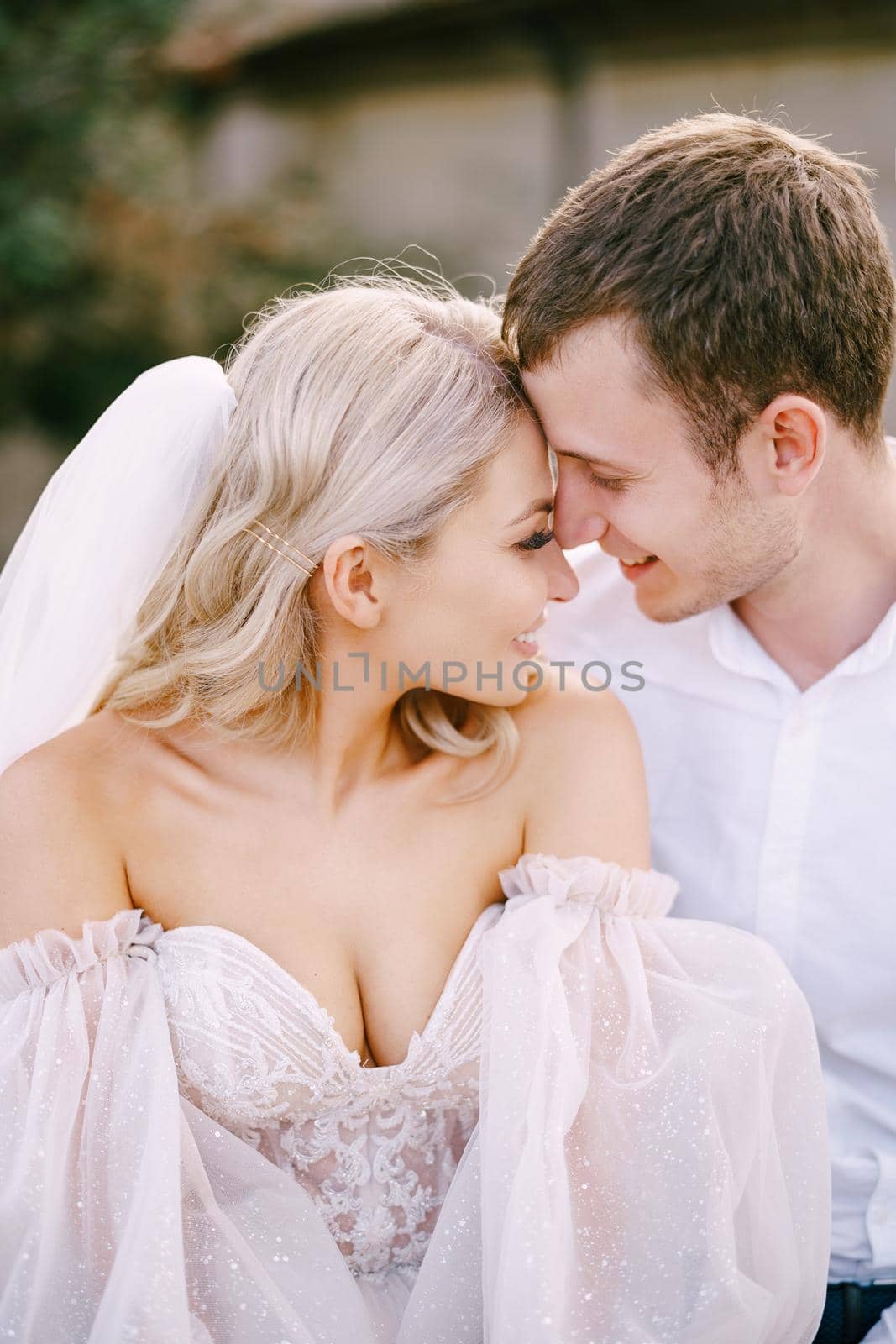 Close-up portrait of a wedding couple, the groom hugs the bride. Wedding at an old winery villa in Tuscany, Italy.