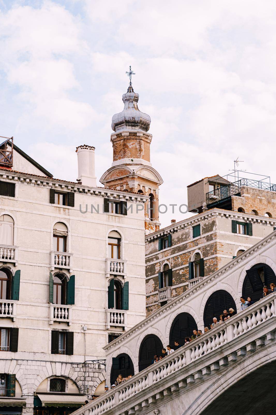 The beautiful Ponte di Rialto Bridge over Central Grand Canal in Venice, Italy, with shops, beautiful views and lots of people. Near boat station of the same name, the street leads to San Marco